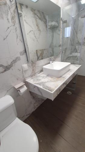 La salle de bains blanche est pourvue d'un lavabo et de toilettes. dans l'établissement Little Troll House 2, Golden Beach,, à Chrissi Akti