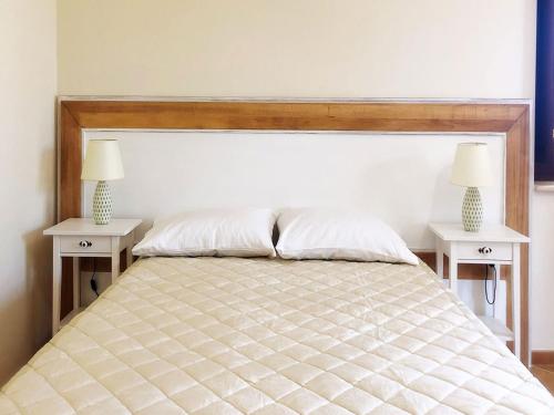 a bedroom with a bed with two white night stands at Agriturismo Casale Cerere in Lacedonia