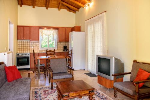 cocina y sala de estar con TV y mesa en Dual house in Methydrio, en Vitina