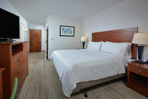 a hotel room with a bed and a flat screen tv at Holiday Inn Express Lynchburg by IHG in Lynchburg