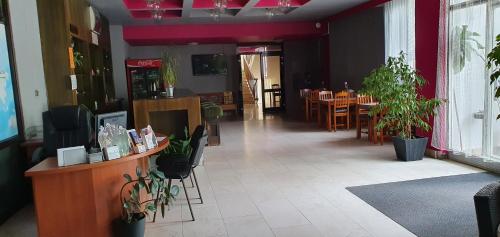 un restaurante con mesas y macetas en una habitación en Hotel Poprad, en Ústí nad Orlicí