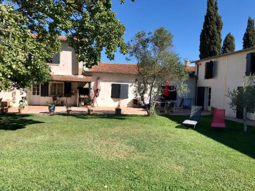 a backyard of a house with a lawn at Mas Du Pont De Laute in Le Cailar