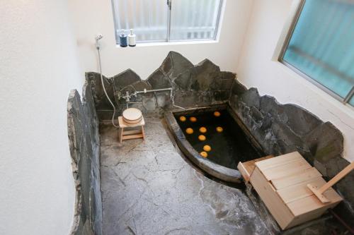 a bath tub with a pool in the corner of a room at かわもと別邸９２６ in Yufuin