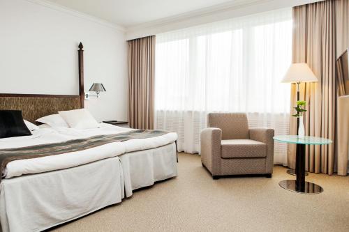 a hotel room with a bed and a chair at Elite Park Avenue Hotel in Gothenburg