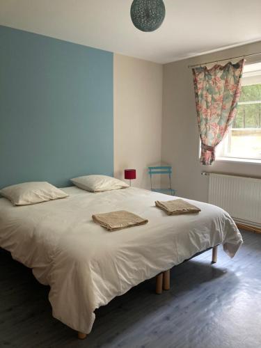 una camera da letto con un grande letto con due asciugamani di Gîte Aux chênes a La Viardière