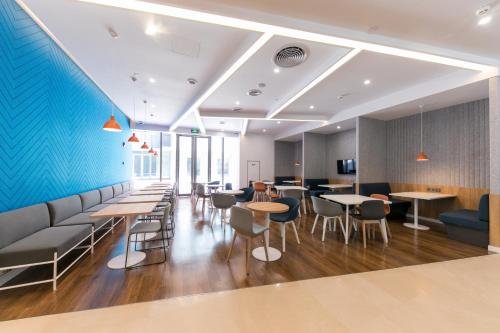 a restaurant with tables and chairs and a blue wall at Holiday Inn Express Shanghai Tangzhen by IHG - 20 mins to PVG Airport and Disney land in Shanghai