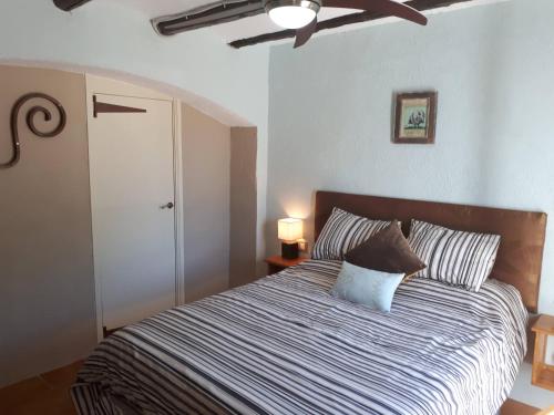 Schlafzimmer mit einem Bett und einem Deckenventilator in der Unterkunft Casa de Bello in Tortosa