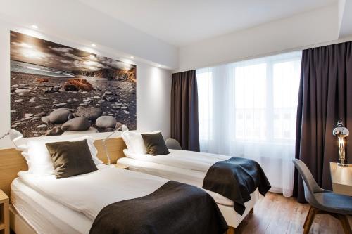 a hotel room with a large bed and a large window at Storm Hotel by Keahotels in Reykjavík