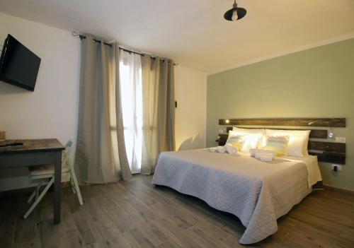 um quarto com uma cama, uma secretária e uma televisão em BnB Anacleto em Bassacutena