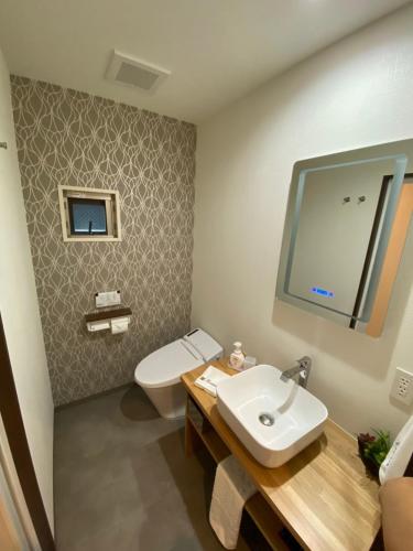 a bathroom with a white toilet and a sink at Kainoa Guesthouse in Tokyo
