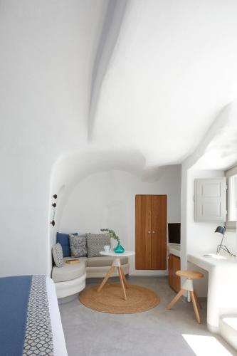 a white room with a couch and a table at Filotera Suites in Oia