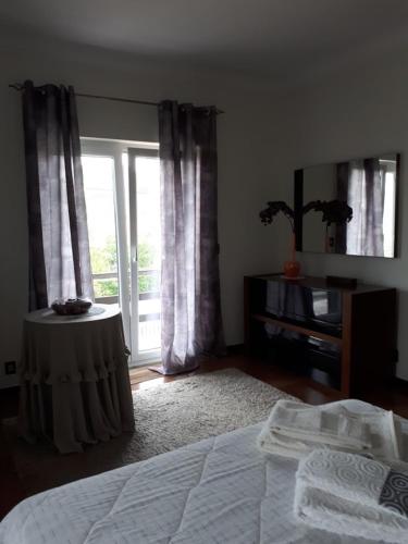 a bedroom with a bed and a large window at Granja MG in Bombarral