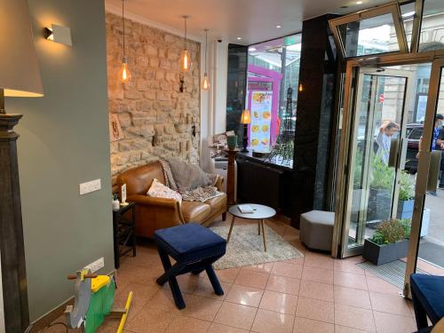a living room with a leather couch and a table at Picardy Hôtel-Gare du Nord in Paris