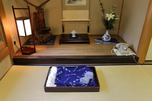 a room with a table with a phone and vases at Yadoya Kikokuso in Kyoto