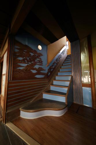a staircase in a house with a painting on the wall at Yadoya Kikokuso in Kyoto
