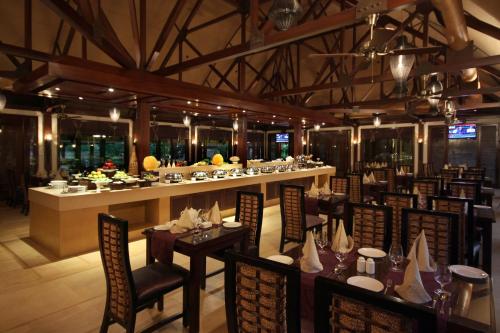 een restaurant met tafels en stoelen en een bar bij Ananta Spa & Resort, Pushkar in Pushkar