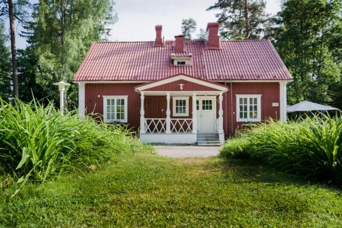 a red and white house with a blue door at Villa Tammikko in Tuusula