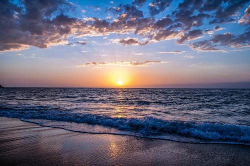 a sunset on the beach with the ocean at Holiday Inn Express San Diego - Sea World Area by IHG in San Diego
