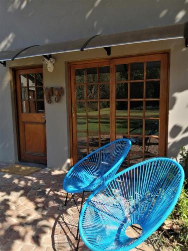 two blue chairs sitting in front of a door at Ikamu's lodge in Germiston