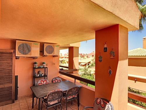 balkon z drewnianym stołem i krzesłami w obiekcie Albatros Playa 3 - 4908 w mieście Mar de Cristal