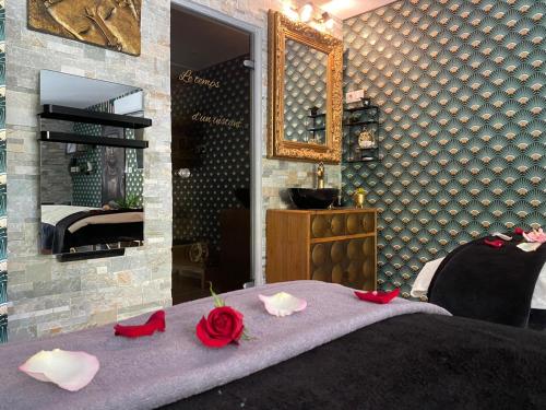 a bedroom with a bed with red roses on it at Suite romantique Le temps d'un Instant Loveroom Hammam jacuzzi piscine in Villeneuve