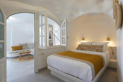 a bedroom with a large bed with an arched doorway at Filotera Suites in Oia
