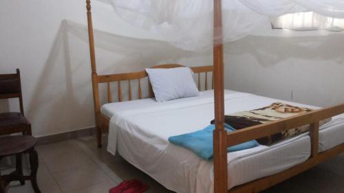 una camera da letto con un letto a castello e una sedia di Highway Motel a Nebbi