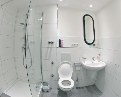 a bathroom with a shower and a toilet and a sink at Restaurant Trocadero in Hannover