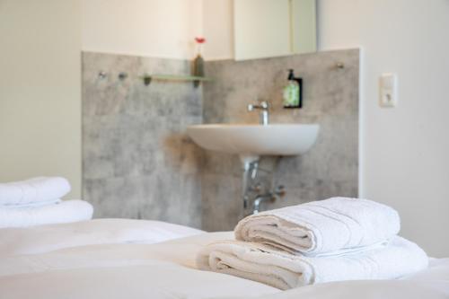 a bathroom with a sink and towels on a bed at Hotel Clement - Bed & Breakfast in Ingelheim am Rhein