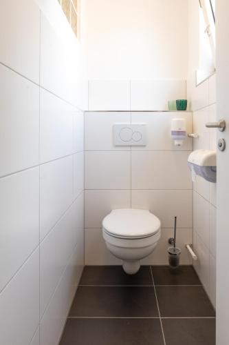 a white bathroom with a toilet and a sink at Hotel Clement - Bed & Breakfast in Ingelheim am Rhein