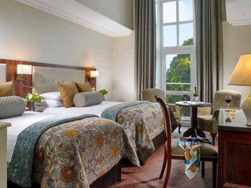 a hotel room with two beds and a window at The Park Hotel Dungarvan in Dungarvan