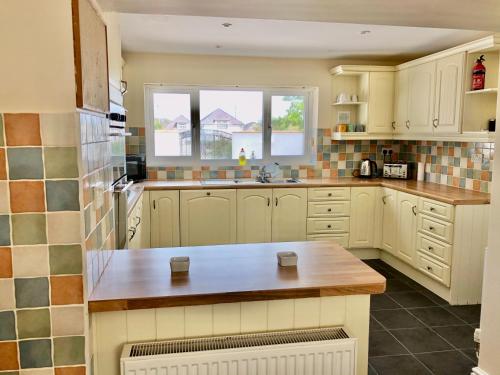 a kitchen with white cabinets and a counter top at Bodarfor in Trearddur
