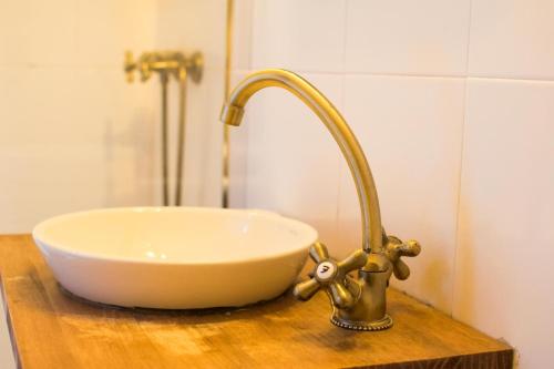 a bathroom sink with a faucet on a wooden counter at Latas Surf Lodge in Loredo
