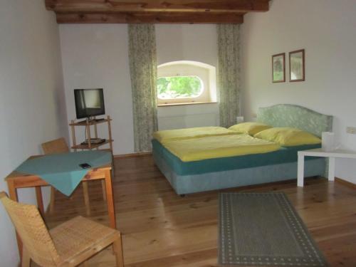a bedroom with a bed and a table and a tv at Schlossbrauerei Weinberg - Erste oö. Gasthausbrauerei in Kefermarkt