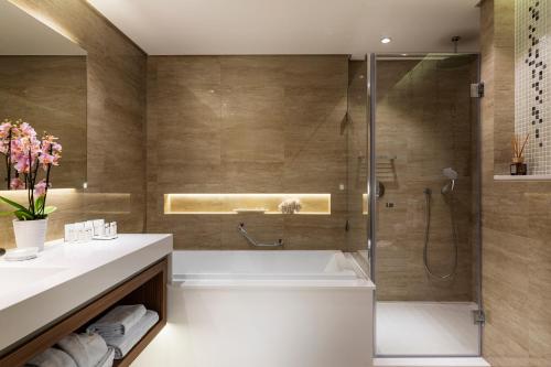 a bathroom with a bath tub and a shower at Grand Hotel Millennium Sofia in Sofia