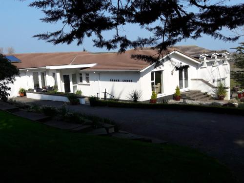 a white house with a brown roof at At Cedar Lodge Apartment in Ramsey