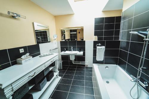 a bathroom with a bath tub and a sink and a bath tub at Ô Rethel Jacuzzi, Gîte Ardennes in Rethel