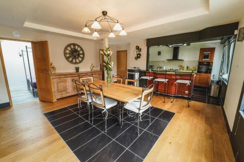 a kitchen and dining room with a wooden table and chairs at Ô Rethel Jacuzzi, Gîte Ardennes in Rethel