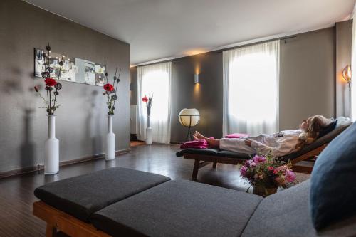 a woman laying in a bed in a living room at Ganter Hotel & Restaurant Mohren in Reichenau