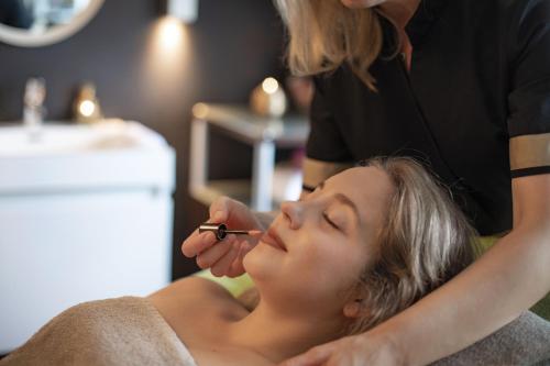 a woman getting her eyebrows brushed by a beautician at Ganter Hotel & Restaurant Mohren in Reichenau