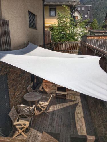 a large white sheet on a balcony with a table and chairs at House Neza in Kranjska Gora