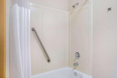a bathroom with a shower with a white shower curtain at La Quinta by Wyndham Springfield South in Springfield