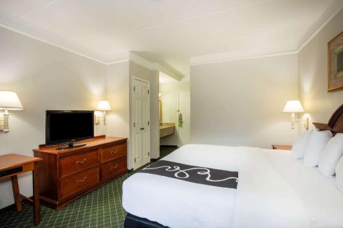a hotel room with a bed and a flat screen tv at La Quinta by Wyndham Melbourne Viera in Melbourne