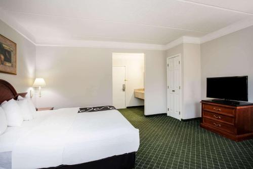 a hotel room with a bed and a flat screen tv at La Quinta by Wyndham Melbourne Viera in Melbourne