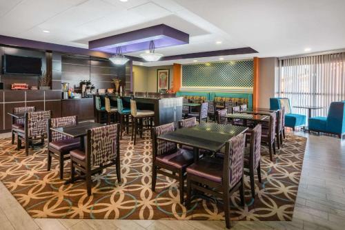 a restaurant with tables and chairs and a bar at La Quinta by Wyndham Memphis Airport Graceland in Memphis