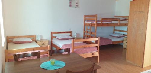 Zimmer mit 3 Etagenbetten sowie einem Tisch und Stühlen in der Unterkunft Apartment Beautiful Črni Kal in Črni Kal