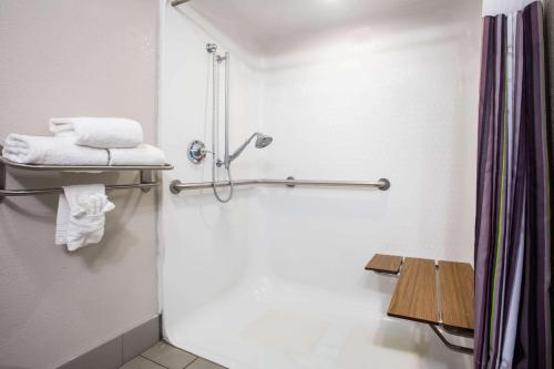 a bathroom with a shower with towels and a sink at La Quinta Inn & Suits by Wyndham Pontoon Beach IL in Pontoon Beach