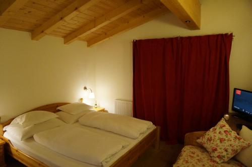 a bedroom with a bed with a red curtain at Haus Senoner in Kitzbühel