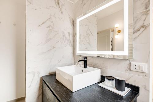 La salle de bains est pourvue d'un lavabo blanc et d'un miroir. dans l'établissement Santa Croce Flat - Modern Apartment, à Florence