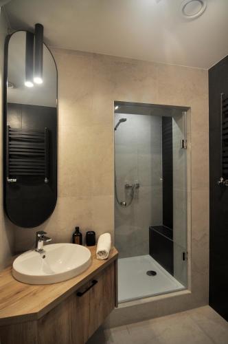 a bathroom with a sink and a shower at Apartamenty Centrum Chodzież in Chodzież